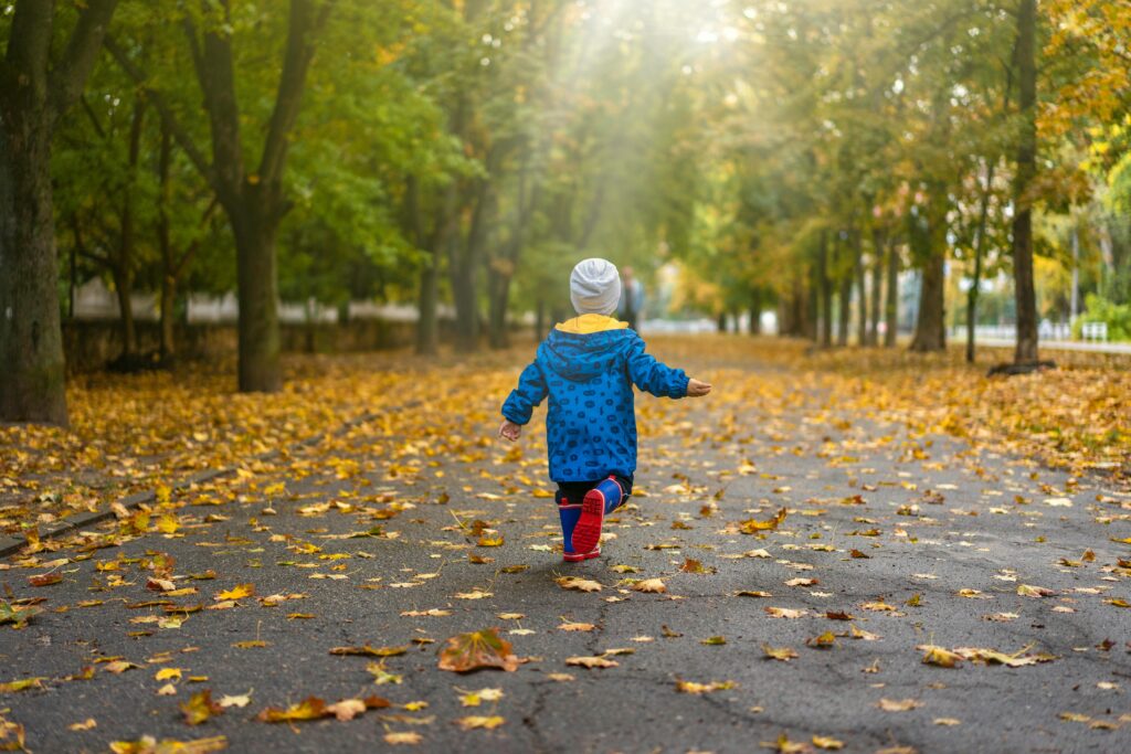 A child running through a meadow, sunlight streaming through the trees