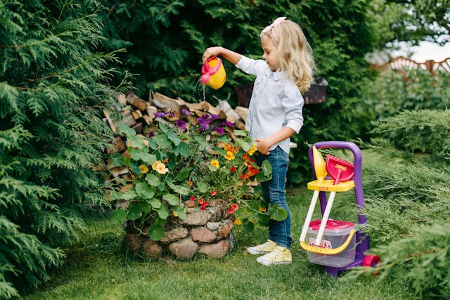 pexels-polesietoys-5997587 Child watering plants in a mini garden.